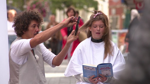 Danny Beuerbach schneidet einem Mädchen die Haare.
