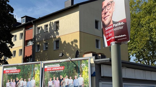 Im vordergrund ist ein Wahlplakat der SPD Dinslaken. Im Hintergund sind zwei große Plakate der SPD Dormagen