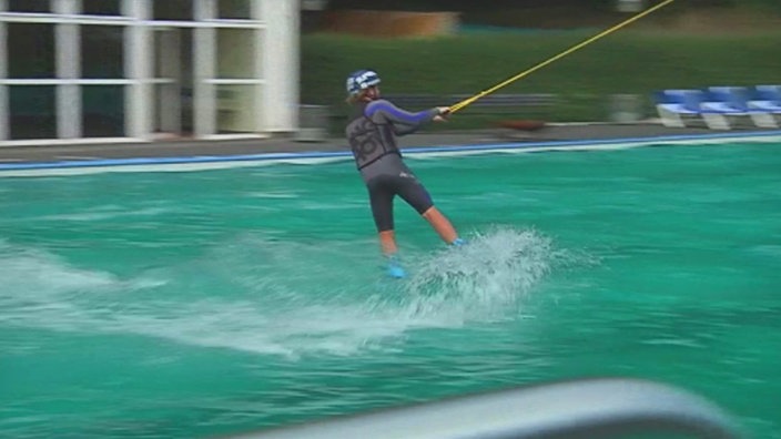 Person mit Wakeboard auf dem Wasser