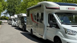 Das Bild zeigt die Wohnmobile, die ein Warteschlange bilden. 