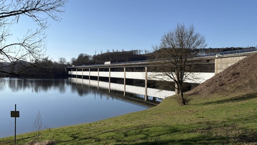 Eine Brücke, die über einen See führt und wegen Bauarbeiten eingehüllt ist.
