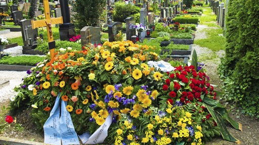 Ein Grab mit Blumen auf einem Friedhof.