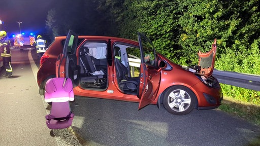 Ein kaputtes Auto, vor dem Kindersitz auf dem Boden steht