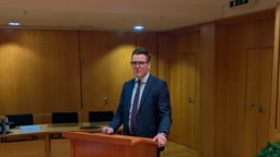 Wendens Kämmerer Thomas Munschek steht im Anzug an einem Tisch