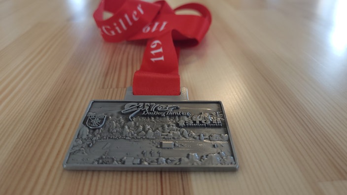 Eine Medaille mit einem roten Band.