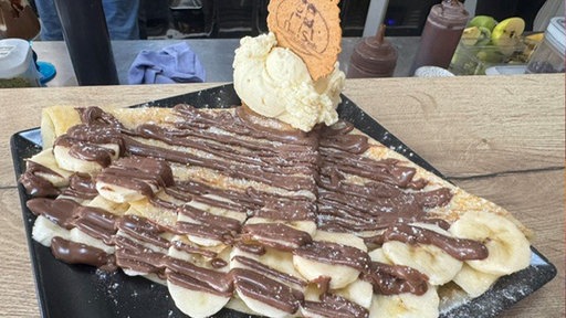 Ein Crèpes mit Banane, Nutella und einer Kugel Vanilleeis