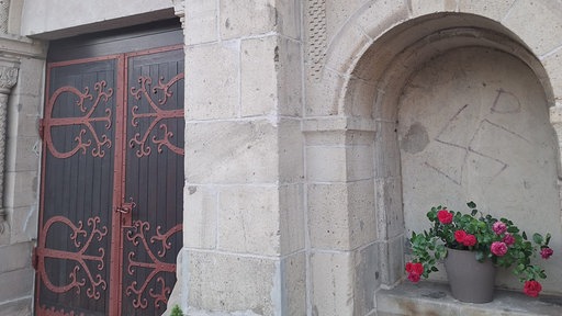 Hakenkreuz direkt neben der Tür einer Kirche