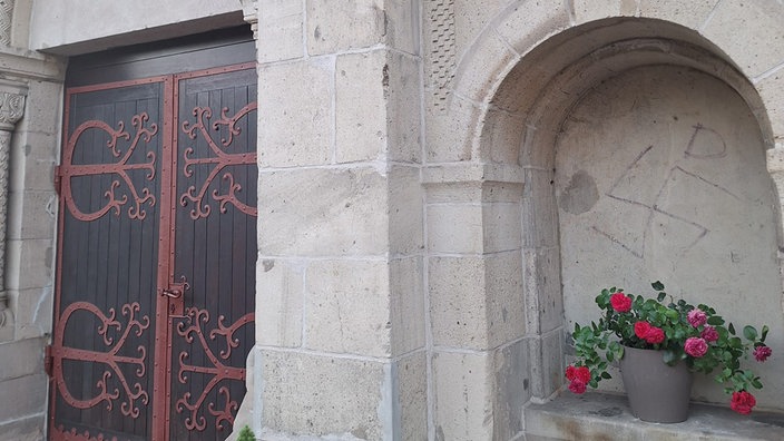 Hakenkreuz direkt neben der Tür einer Kirche