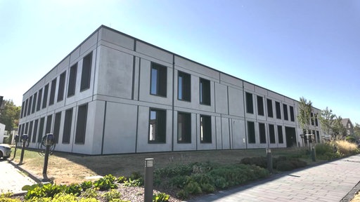 Ein graues Gebäude mit dunklen Fenstern