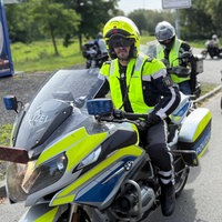 Polizist auf Motorrad gefolgt von anderen Motorradfahrern
