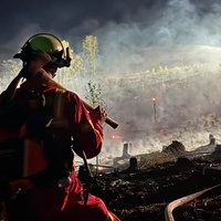 Feuerwehrmann von hinten bei Löschungsarbeiten