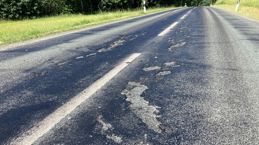 Eine Strasse mit Asphaltschäden.