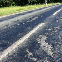 Eine Strasse mit Asphaltschäden.