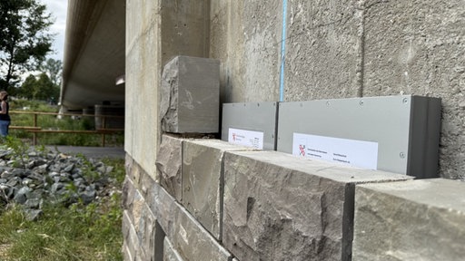 Zeitkapsel wird hinter einer Mauer versenkt