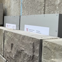Zeitkapsel wird hinter einer Mauer versenkt
