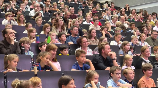 Kinder mit ihren Eltern im Vorlesungssaal 