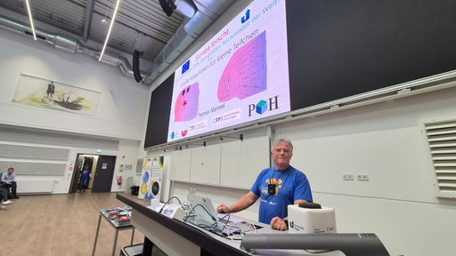 Physikprofessor Thomas Mannel steht vorne im Vorlesungssaal 