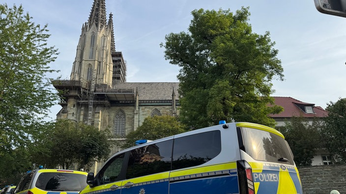 Mehrere Polizeiwagen stehen vor einer Kirche