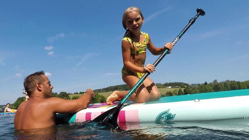Papa Dennis und seine Tochter auf dem Stand-up-Paddle-Board