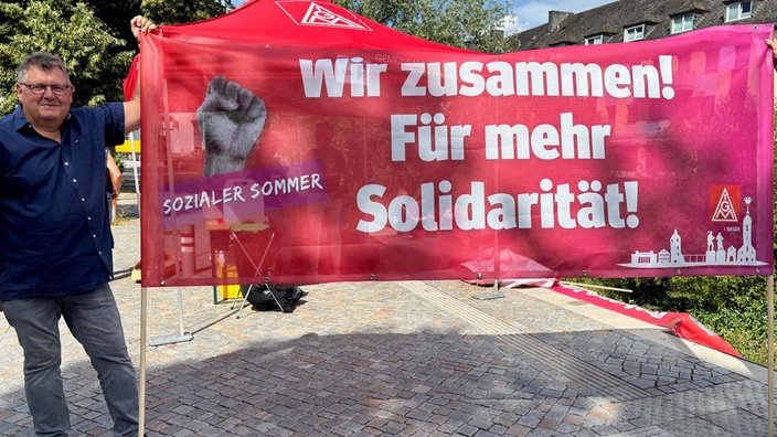 Rotes Banner mit Aufdruck "Wir zusammen! Für mehr Solidarität"