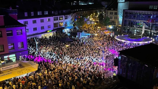Eine Luftaufnahme bei Nacht einer Menschenmenge, die das Stadtfest Siegen besucht hat.