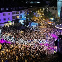 Eine Luftaufnahme bei Nacht einer Menschenmenge, die das Stadtfest Siegen besucht hat.