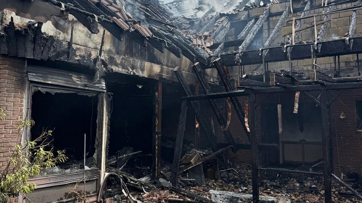 Ein abgebranntes Wohnhaus mit verkohlten Balken