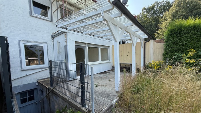 Ein Haus mit Garten und kleiner Überdachung.