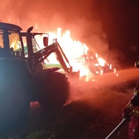 Brennende Strohballen werden von der Feuerwehr gelöscht