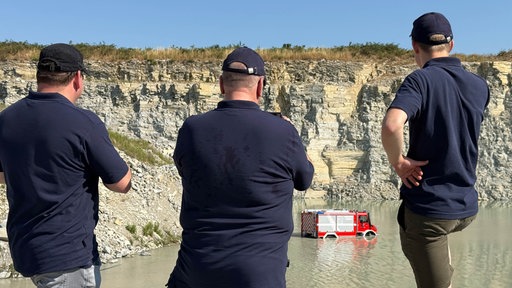 Feuerwehr beobachtet Feuerwagen im Wasser