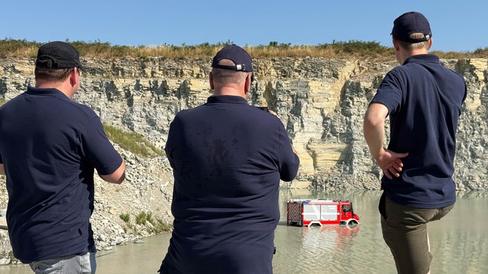 Feuerwehr beobachtet Feuerwagen im Wasser