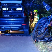 Ein Fahrrad angelehnt an die Leitblanke, dahinter ein Auto und Rettungsdienst 