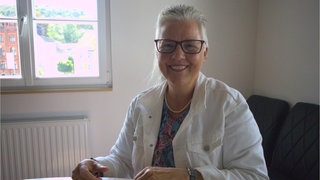 Eine Frau schaut in die Kamera.