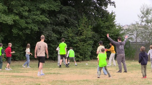 Kinder spielen auf einer Wiese