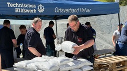 THW-Helfer füllen Sandsäcke