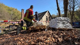 Feuerwehrmann schleppt Sandsäcke