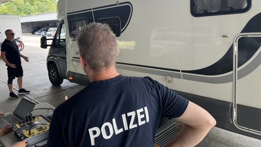Ein Polizist betreut das Wohnwagen-Wiegen.