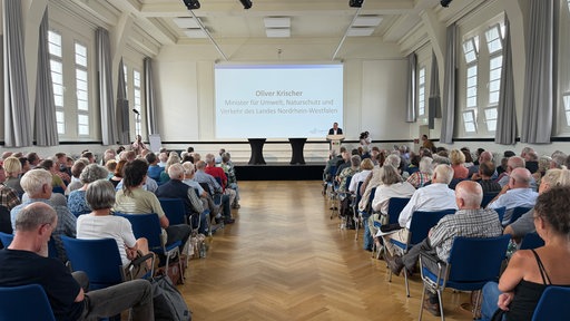 Ein Mann steht auf einem Podest und hält eine Rede