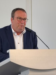 Ein Mann steht auf einem Podest und hält eine Rede