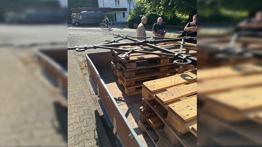 Ein Turmkreuz liegt auf einem Anhänger