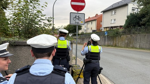 Mehrere Polizisten stehen für eine Kontrolle einer Straße