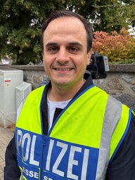 Ein Polizist lächelt in die Kamera