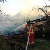 Ein Brand wird von einer Feuerwehrfrau gelöscht.