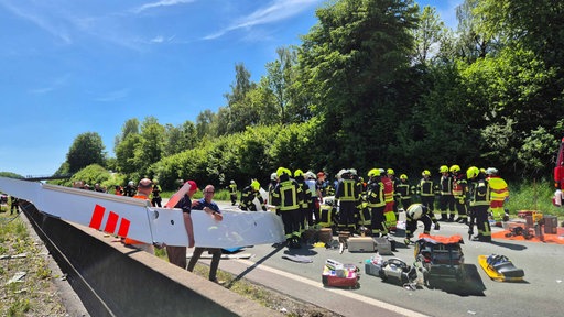 Das Segelflugzeug auf der Fahrbahn, viele Rettungskräfte sind zu sehen