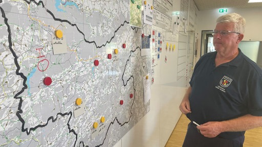 Mitglied des Stabs vor einer Karte der Region 