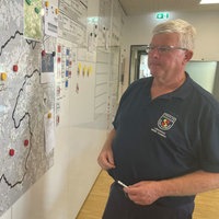Mitglied des Stabs vor einer Karte der Region 