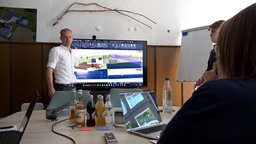 Clemens Wullenweber steht vor einem Monitor und erläutert die Pläne.