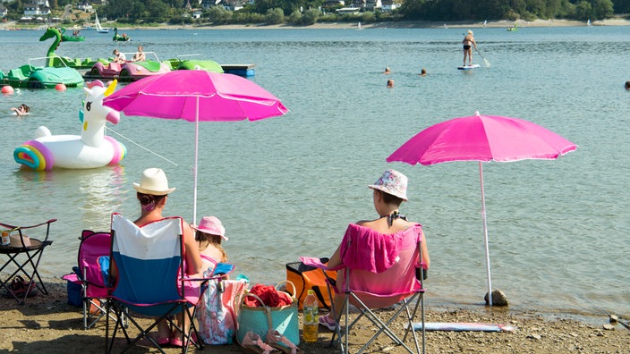 Badegäste sitzen an einem See