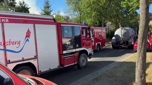 Ein LKW mit einem Güllefass fährt gemeinsam mit Feuerwehrwagen auf einer Straße