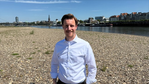 Thomas Vieten von der IHK Düsseldorf steht am Rhein.